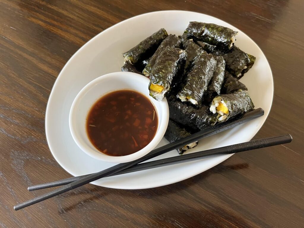 Turmeric-tofu and Sesame-brown-rice wrapped in seaweed. Ginger-garlic spicy soy dipping sauce.