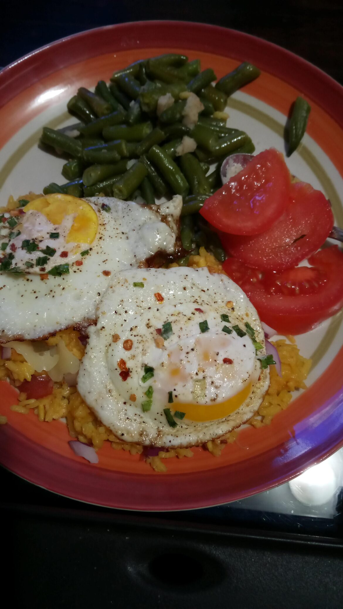 Sunny side ups on top of leftover Spanish rice