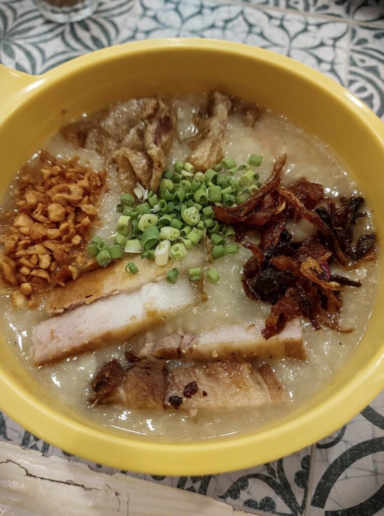 Goto (rice porridge) cooked with ginger and garnished with chicharon bulaklak (deep fried pork intestine) and bagnet (crispy deep fried pork belly) ~ Philippines