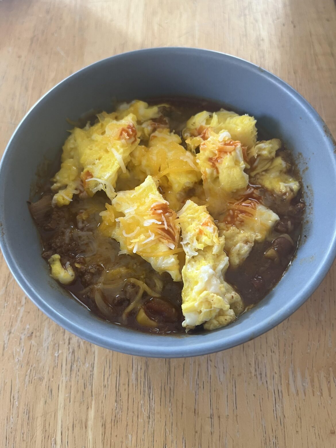 Chili topped with scrambled egg. Leftovers to breakfast.
