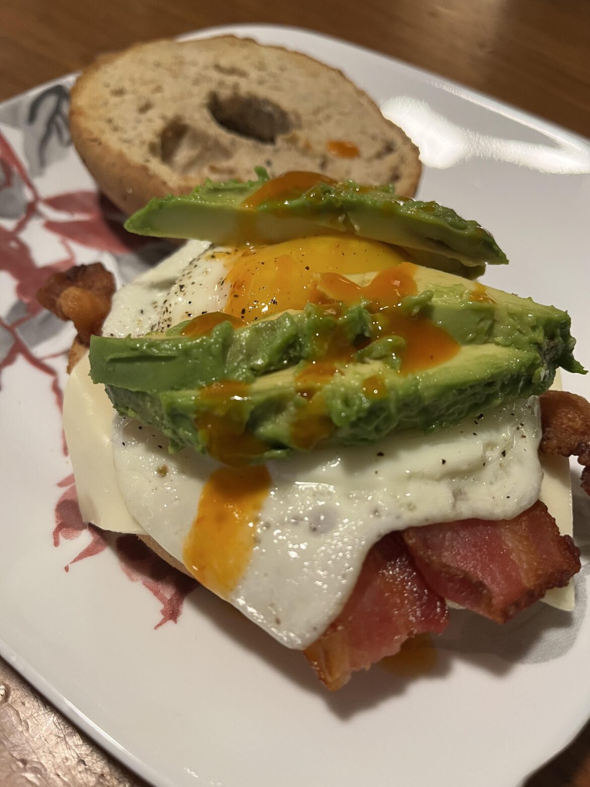 Fried egg on an everything bagel with American cheese, bacon, avocado and ghost pepper hot sauce!