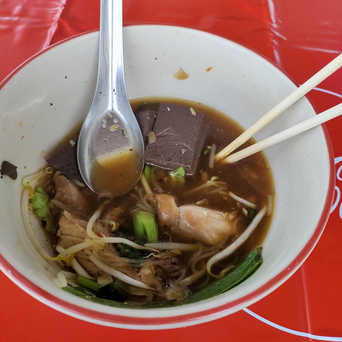 a bowl of chicken noodle on roadside restaurant