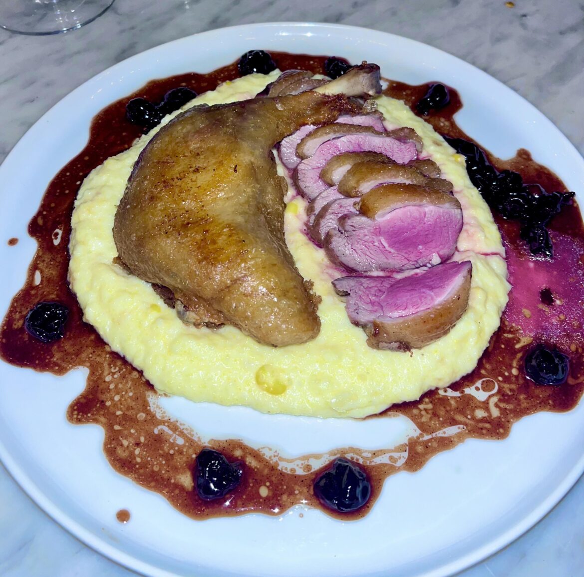 half duck w/ sweet corn polenta + macerated cherries from Cento Pasta Bar