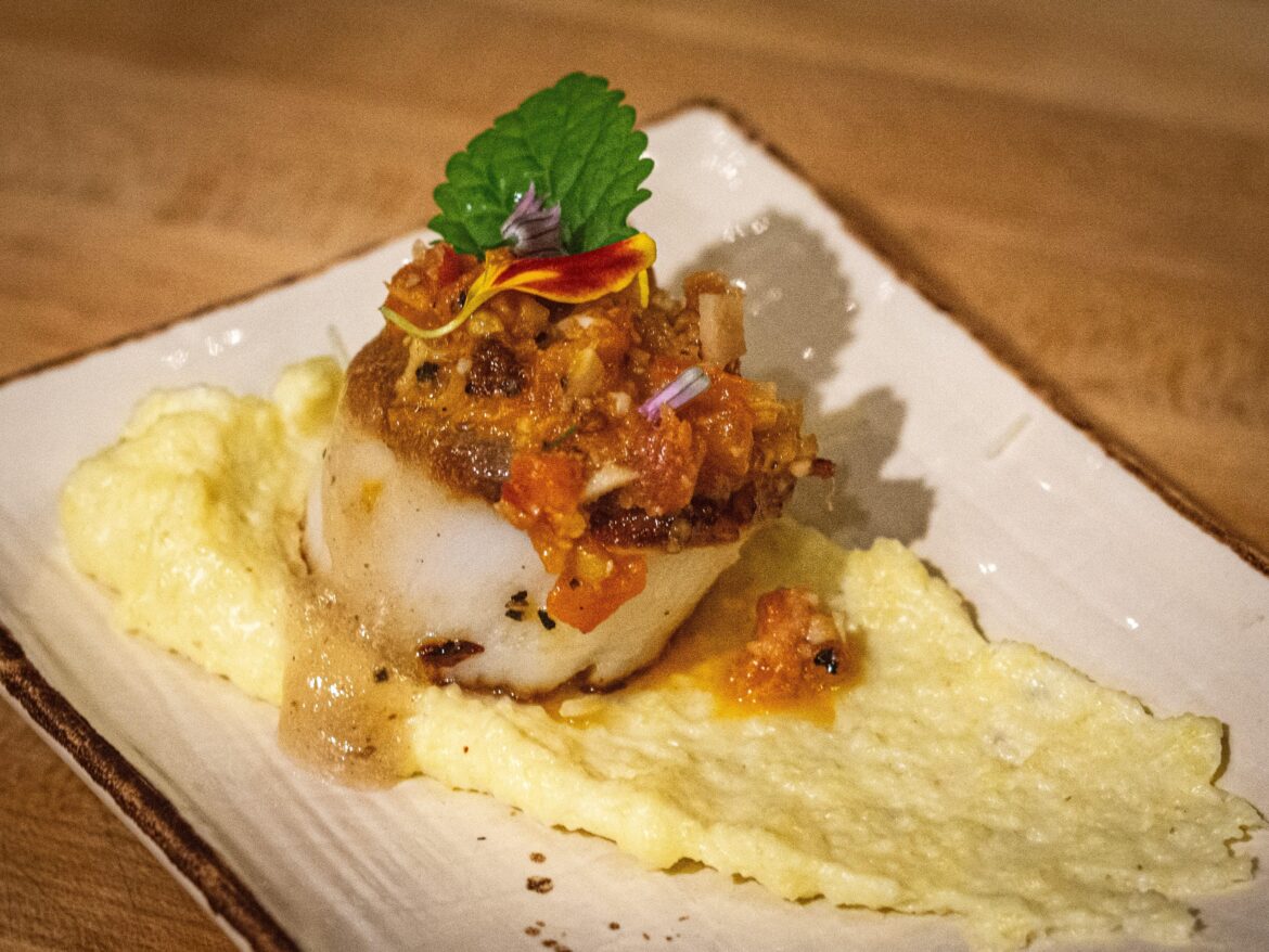 Seared scallop, polenta, pork belly salsa, lemon balm, chive blossom, thickened fish stock