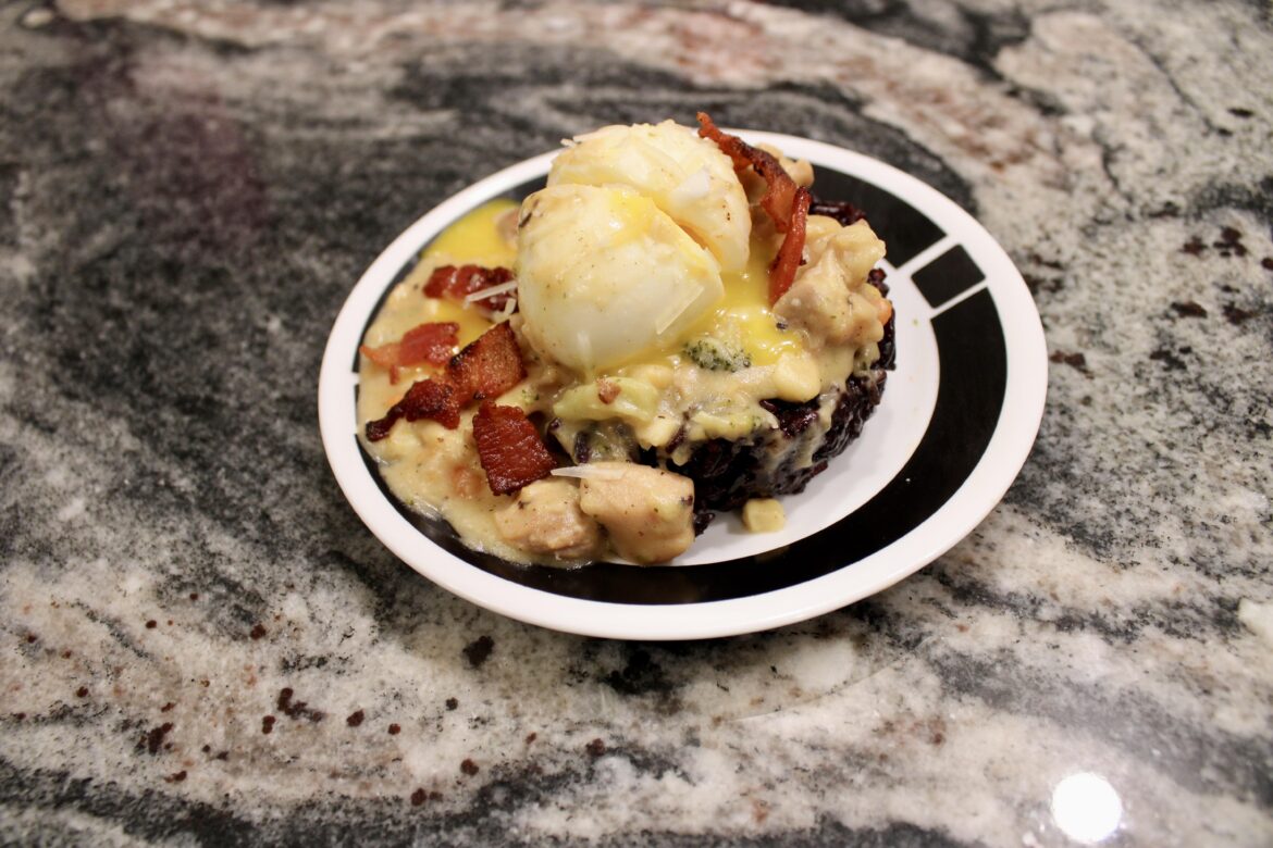 Creamy chicken & veggies, black rice, with bacon, and runny egg on top.