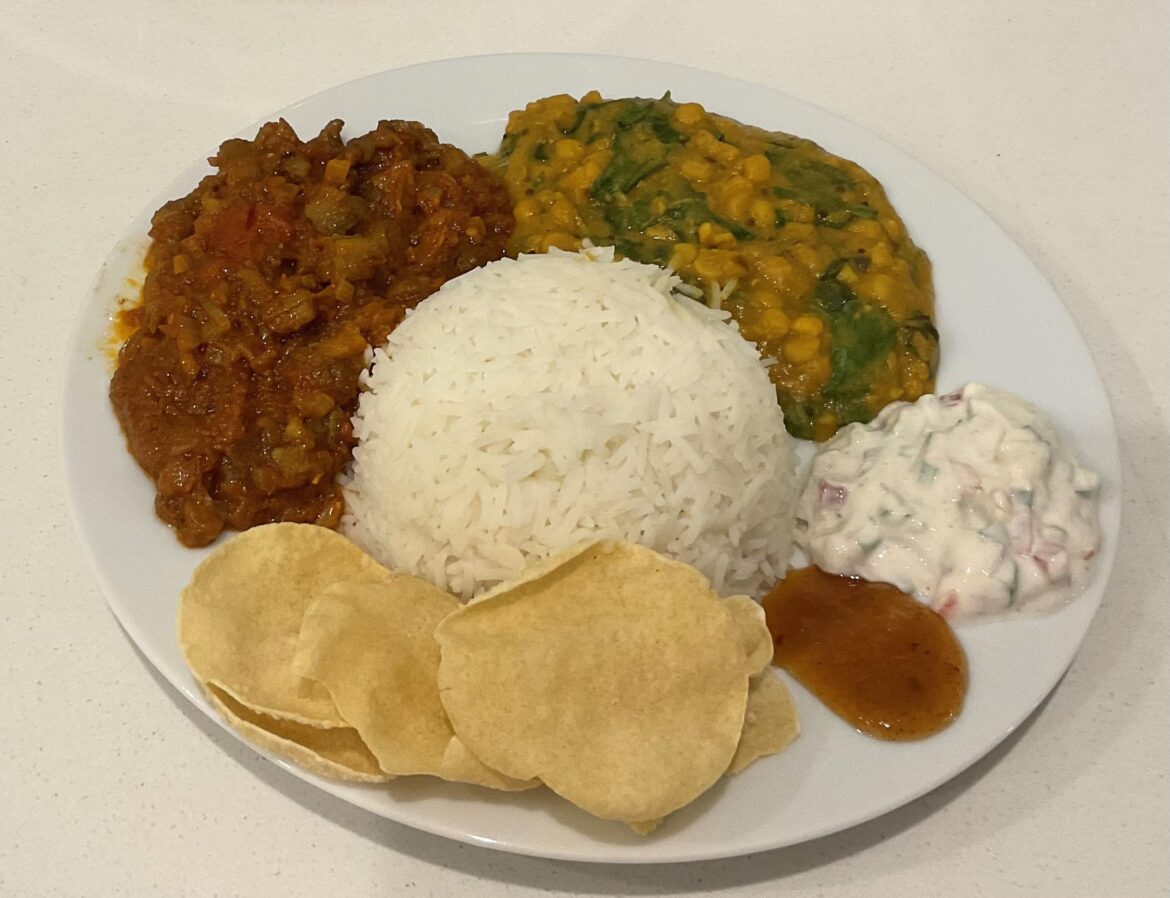 Tarka daal, eggplant curry, rice, raita, mango chutney and pappadums.