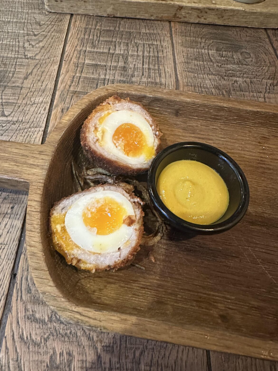 Scotch egg in a wooden shovel.
