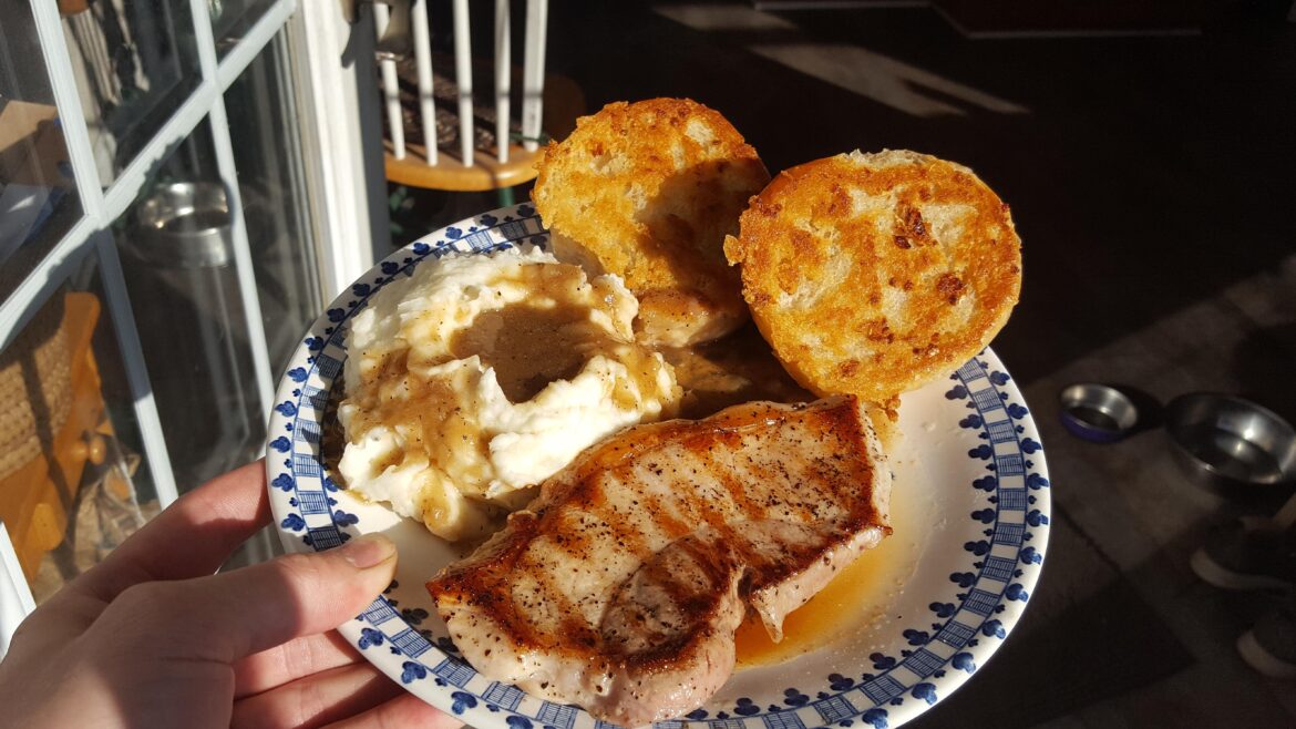 Pork chop, garlic mash potatoes w/ gravy, pan fried garlic bun