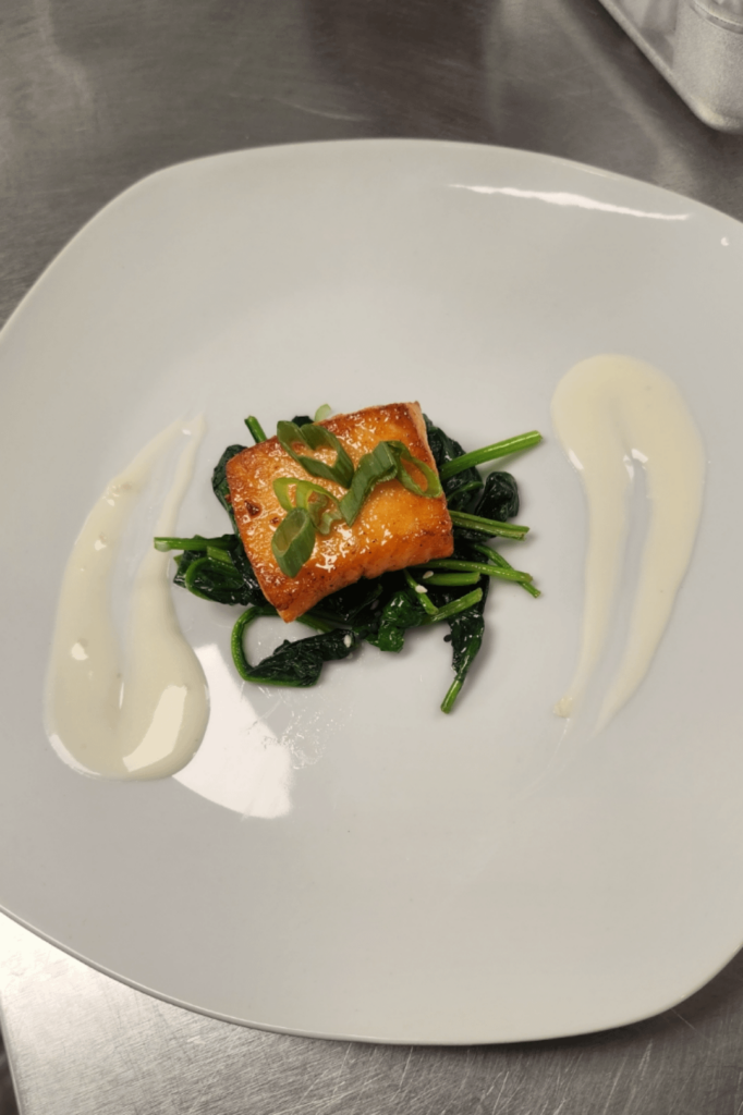 Honey glazed salmon with a creamy lemon sauce and wilted spinach