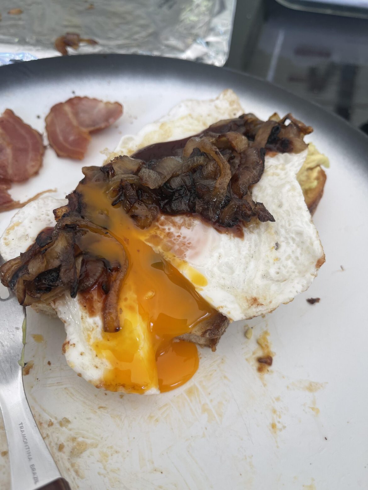 Breakfast today! Sourdough with avo, crispy bacon, egg, caramelised onion and spicy bbq sauce. All cooked on the barbie.