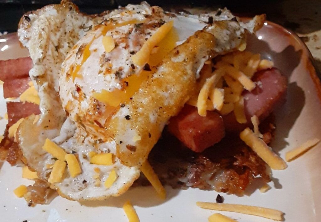 Homemade hashbrown, spam, and cheese all topped with an herb dusted duck egg