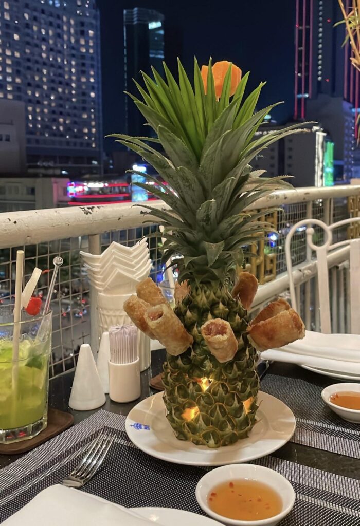 I mean it is technically on a plate… but spring rolls served suspended from a pineapple