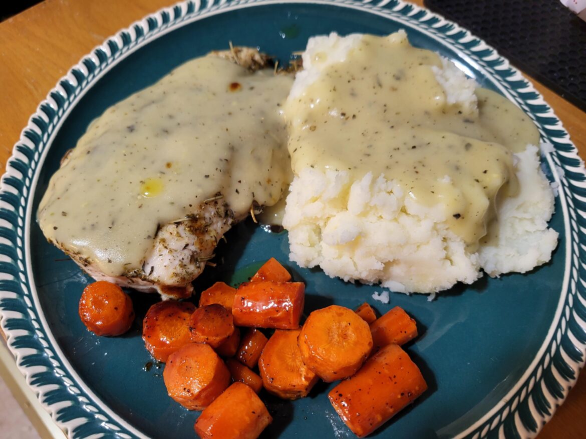 Baked chicken with mashed potatoes, gravy, and honey-roasted carrots.