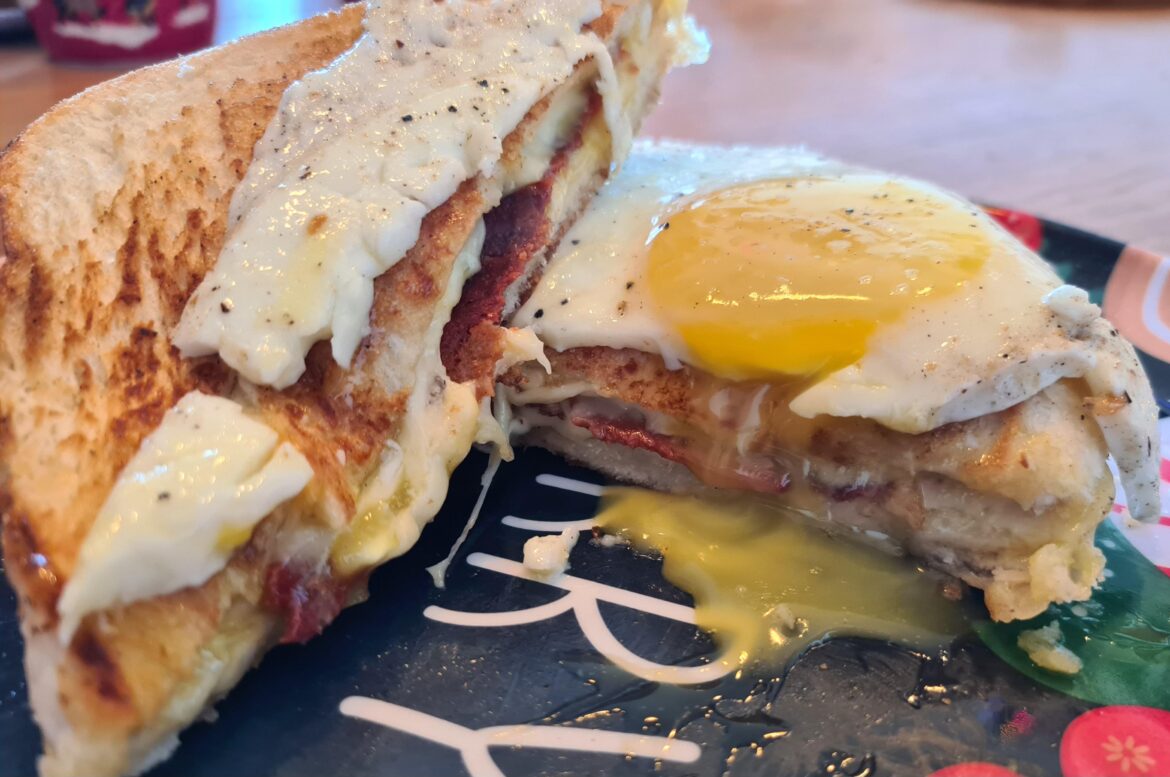 Grilled cheese with vegan bacon, topped with a delicious sunny side up egg