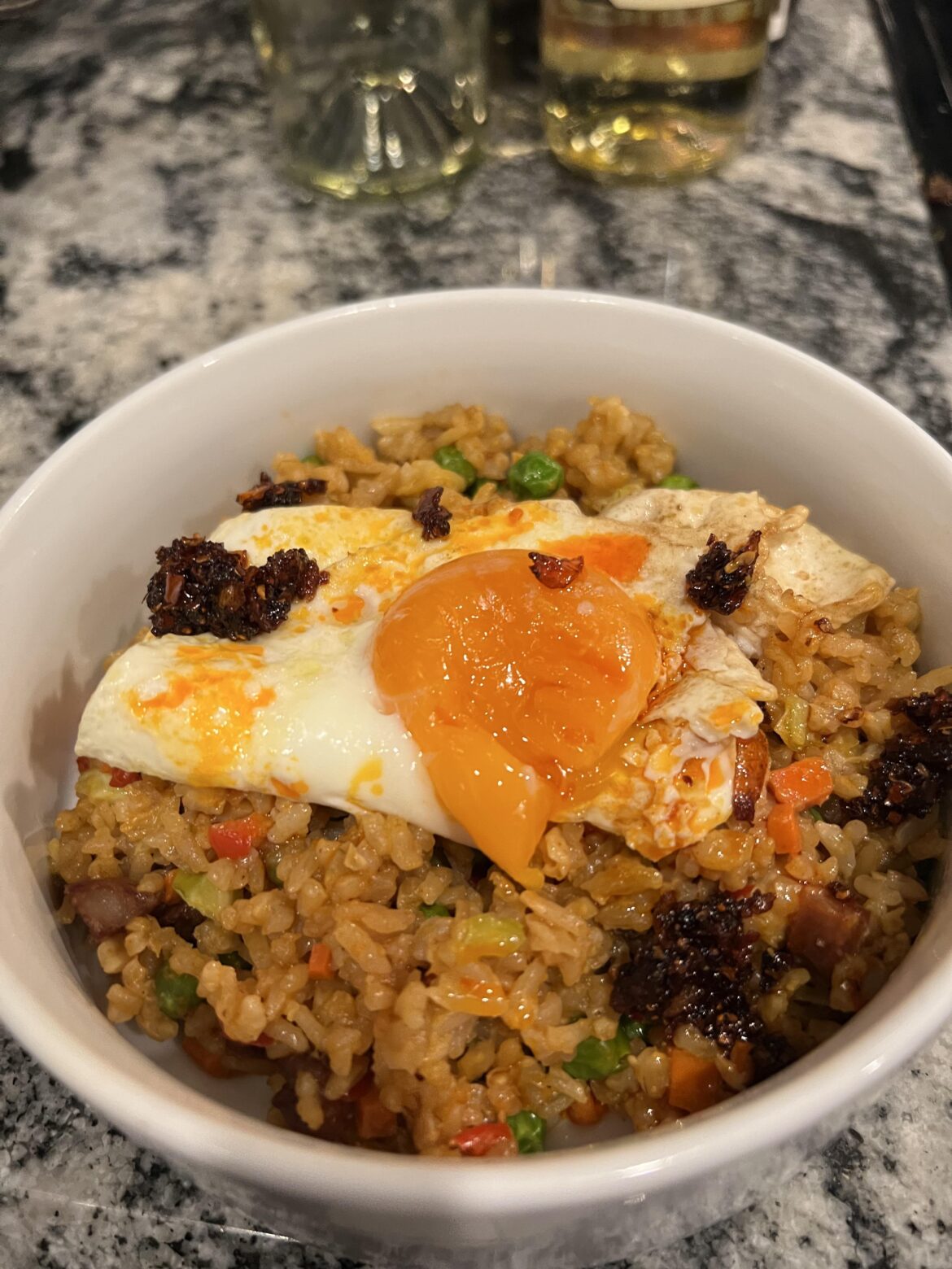 An egg over leftover fried rice with chili crisp. Sadly, a little over cooked