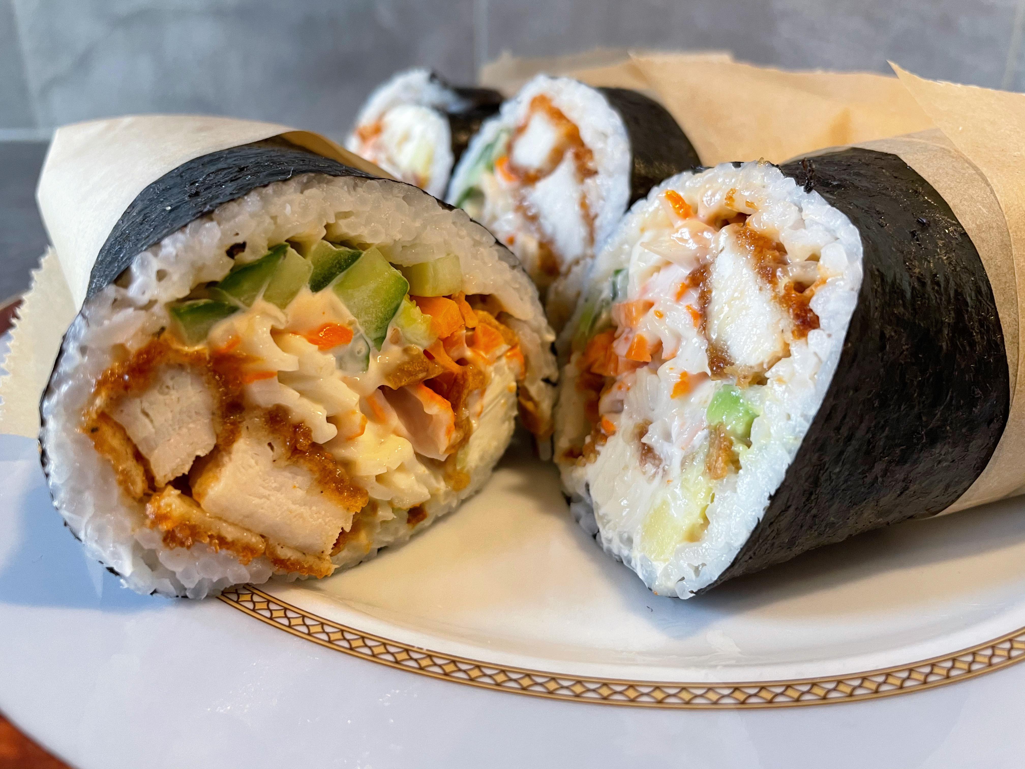 Sushi burrito consisting of panko chicken, imitation crab, cucumber