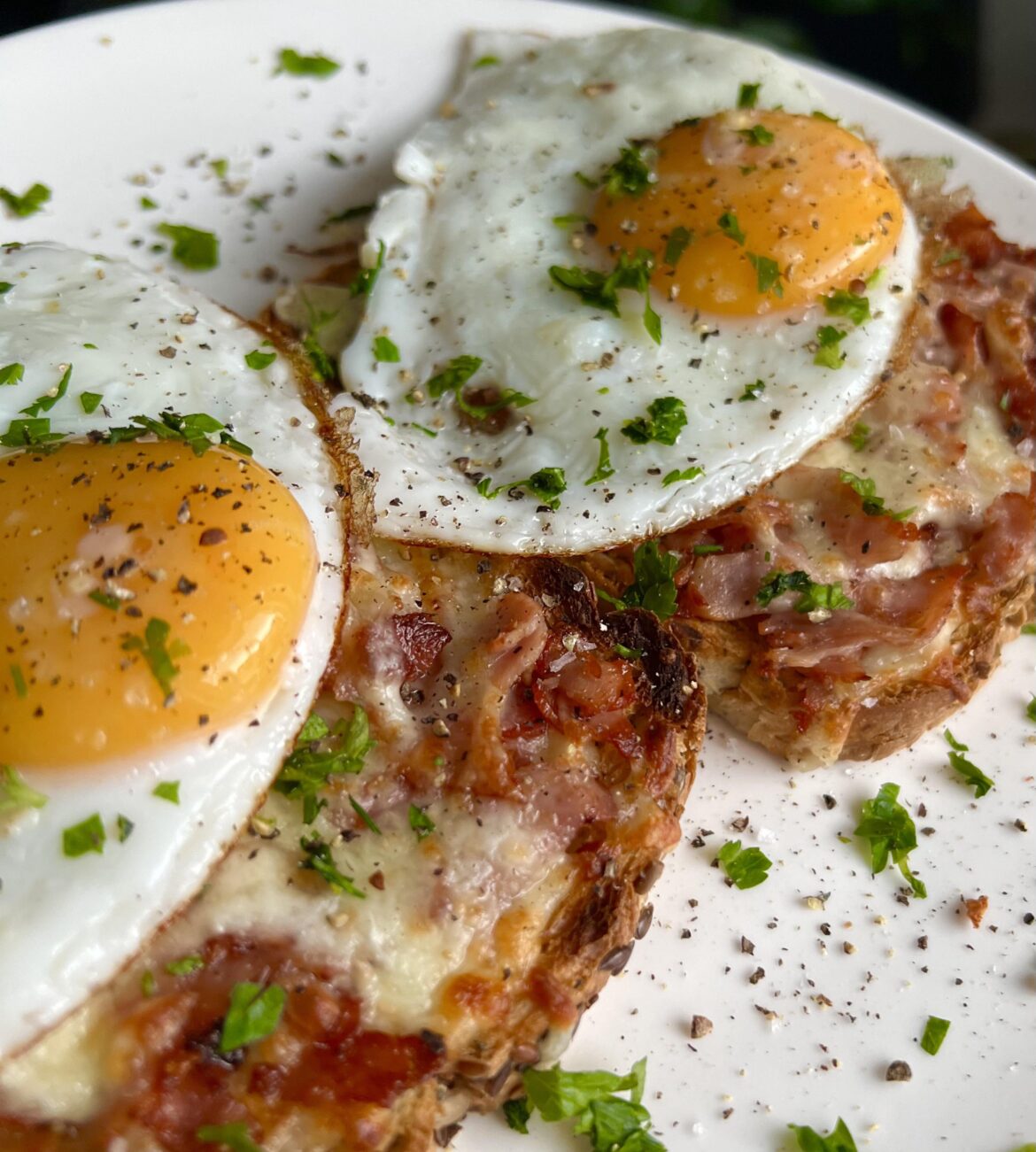 Cheese on toast with cheddar, mozzarella and smoked ham, topped with two fried eggs.