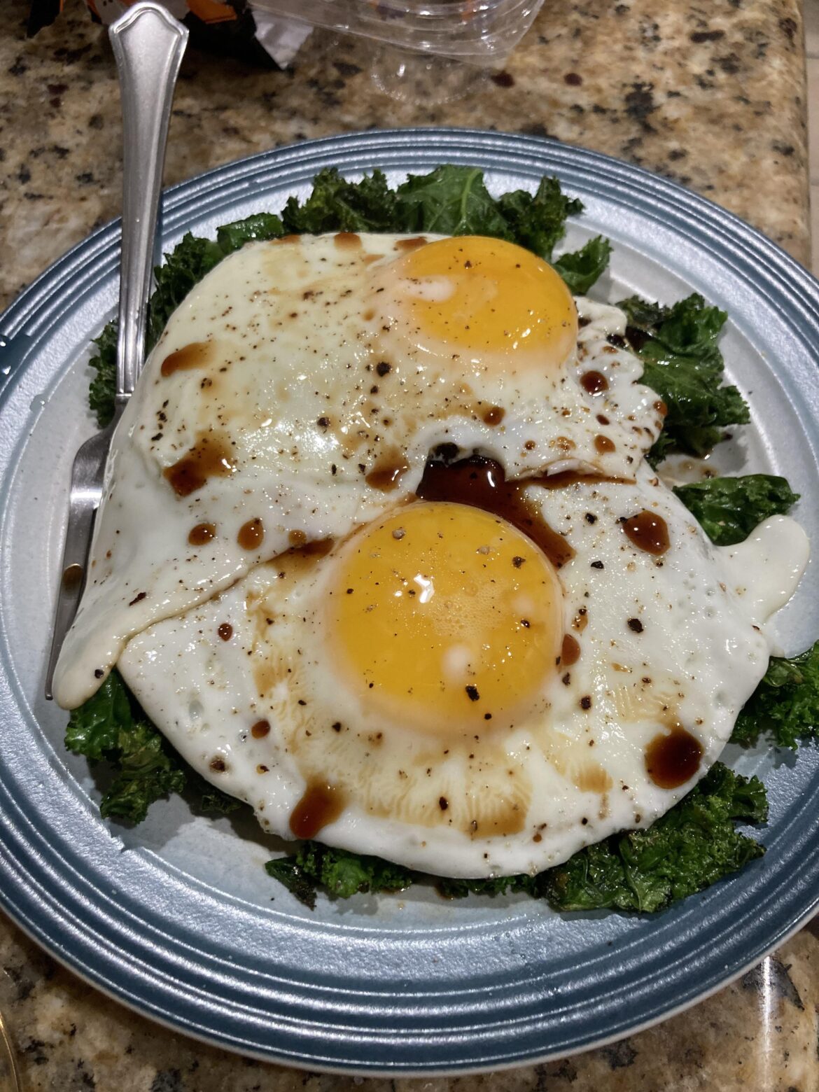 Two eggs over a bed of kale drizzled with soy sauce... NOMNOMNOM