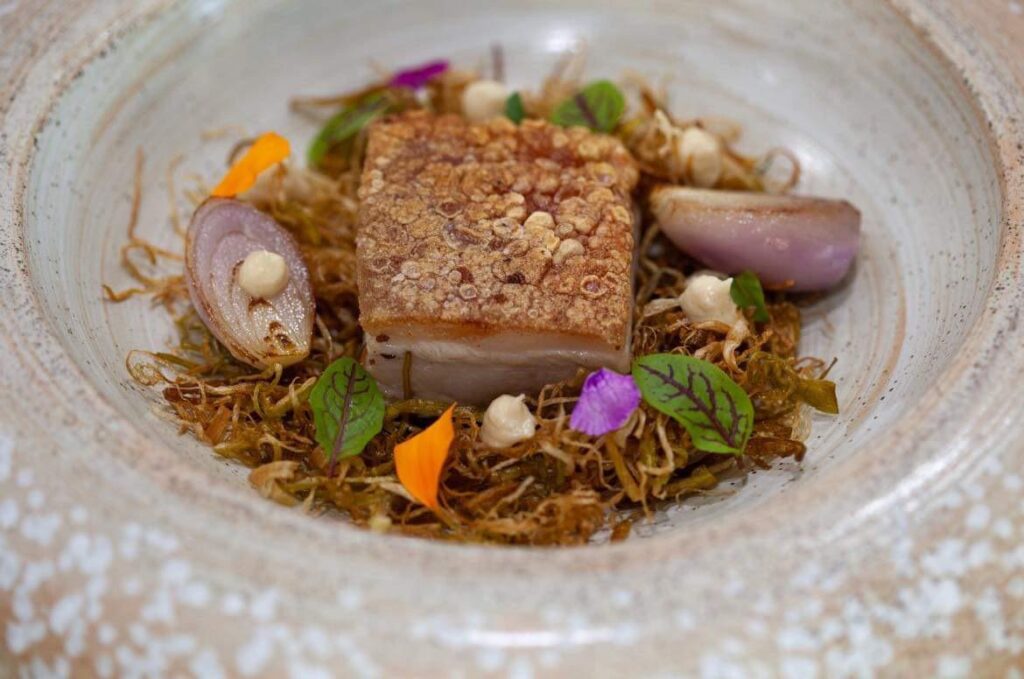 Pork belly on leek hay, shallots, brown butter cauliflower purée and a black garlic glacé