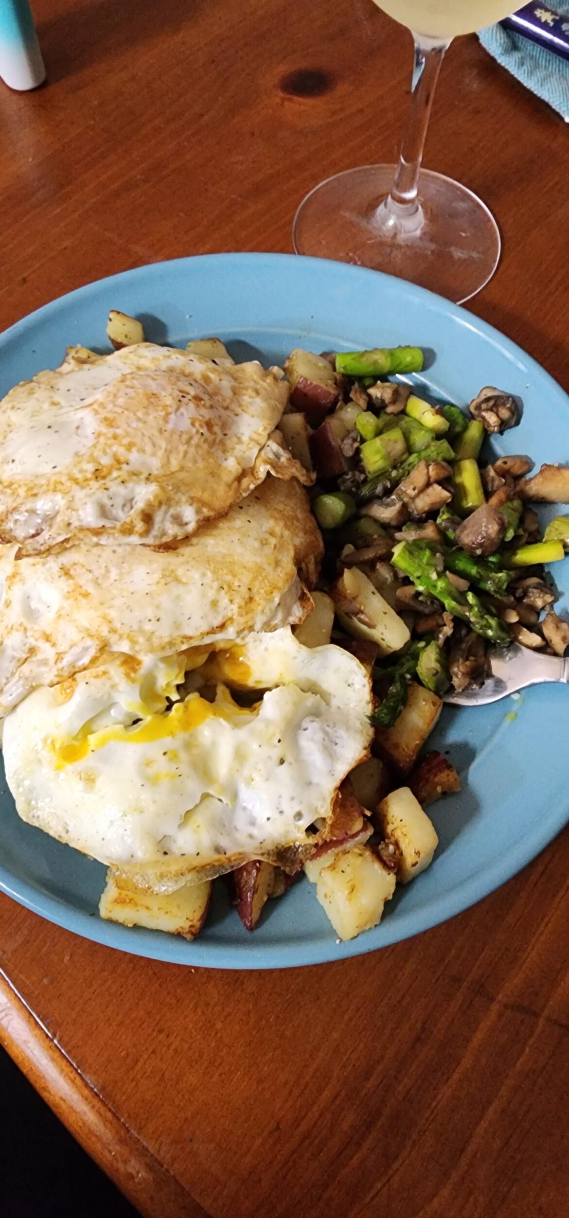 fried eggs over sautéed red potatoes, with a side of portobello and asparagus