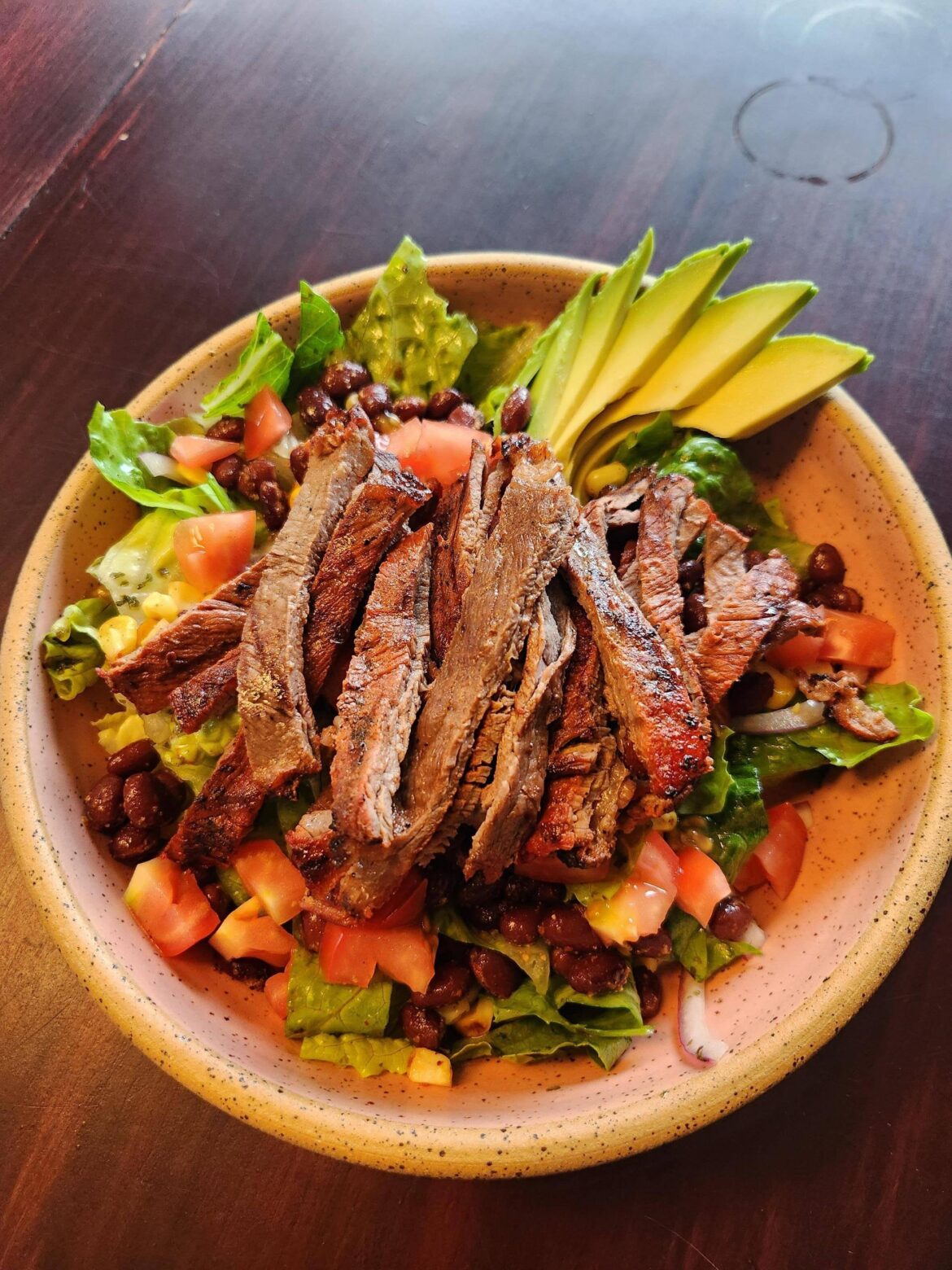 [I made] Carne asada salad with romaine, roasted corn, sessions black beans tom's, avo, cilantro lime dressing