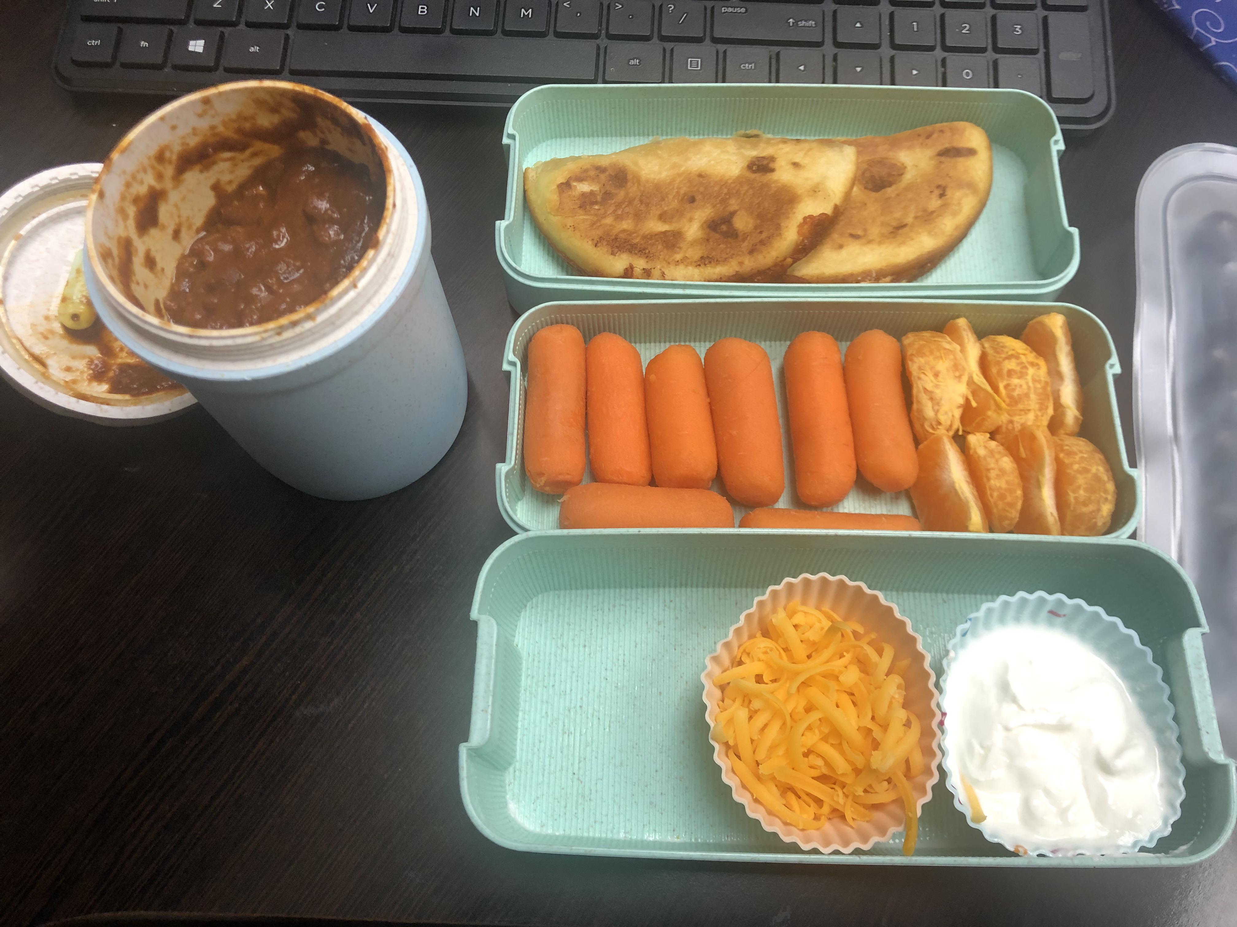 Chilli with grilled cheese, toppings, carrots, and oranges. Dining