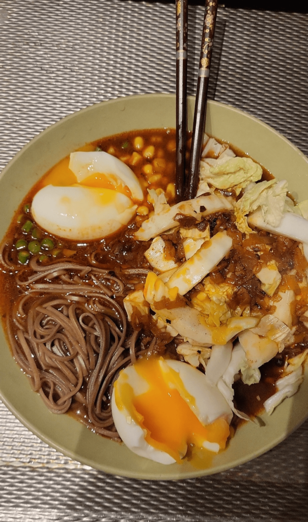 Noodles with cabbage, sweet corn, garlic stems and 2 soft boiled eggs
