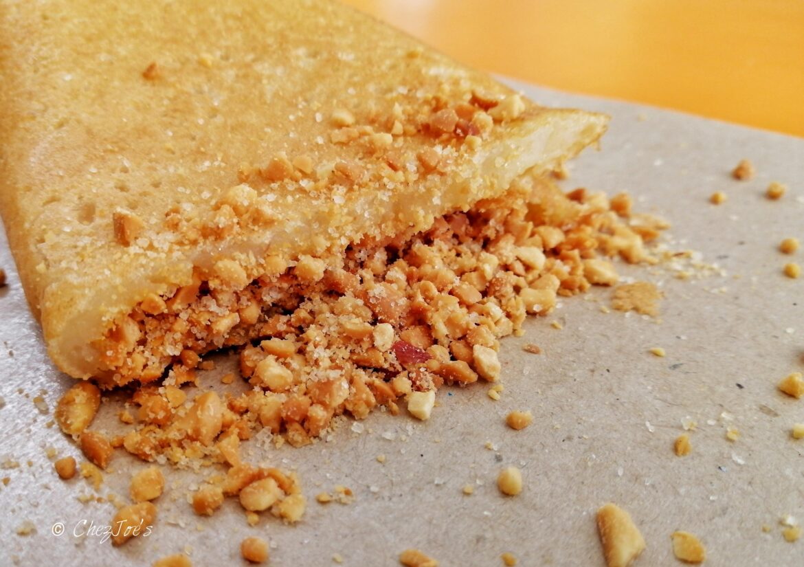 An Asian pancake - spongy, springy crumb with a mostly crispy crust and filled with sugar & ground peanuts. Known by many names in SE Asia, in Singapore it is called mian chiang kueh.