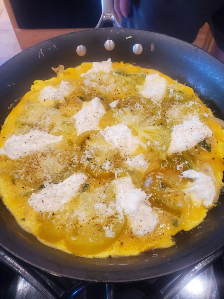 Lidia Bastianich frittata with green heirloom tomatoes, basil, ricotta. Before cook, plated. Having Pinot Noir. Brunch!!!