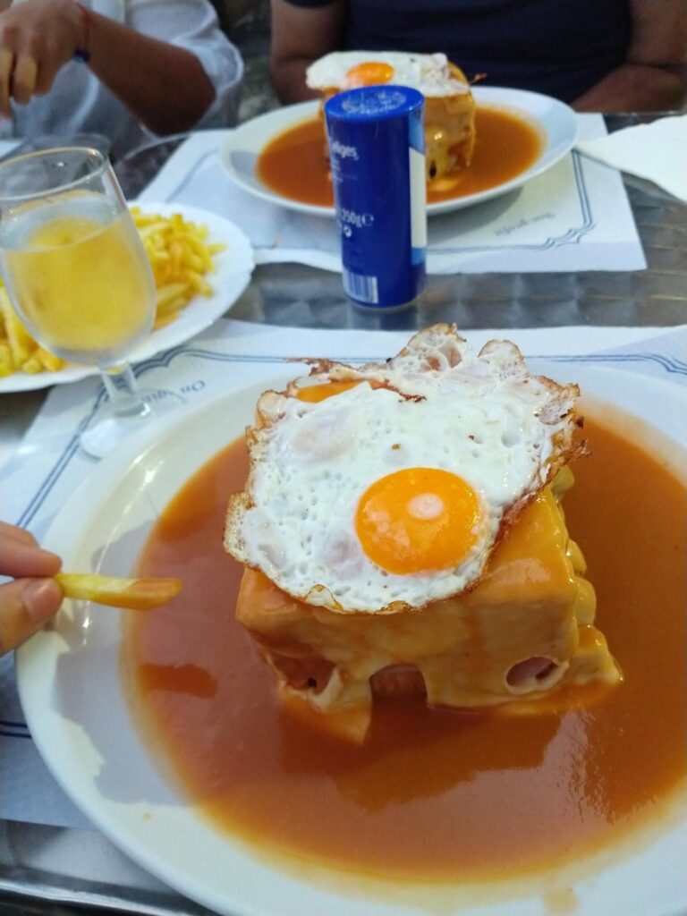 This is a Francesinha, a portuguese streetfood from Porto, it's a triple sandwich filled with ham, chorizo sausage, steak, cheese, tomato and lettuce. Then topped with more cheese, a fried egg and a special sauce(+fries🤤🤤). For more content follow @cronos_dacook on my instagram😋🍔🔥