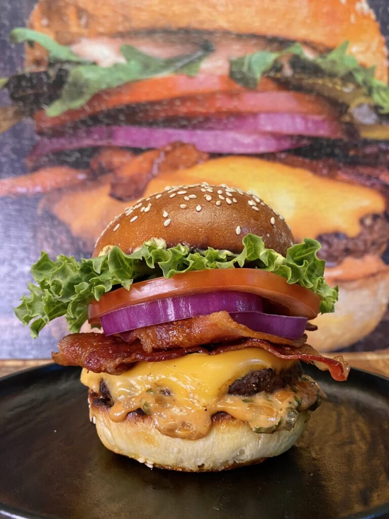 Grilled bacon cheeseburger on a freshly baked brioche bun with homemade secret sauce