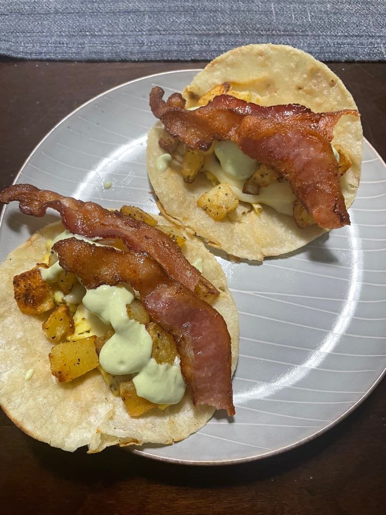 Bacon and potato breakfast tacos in pan fried corn tortillas. Valentina