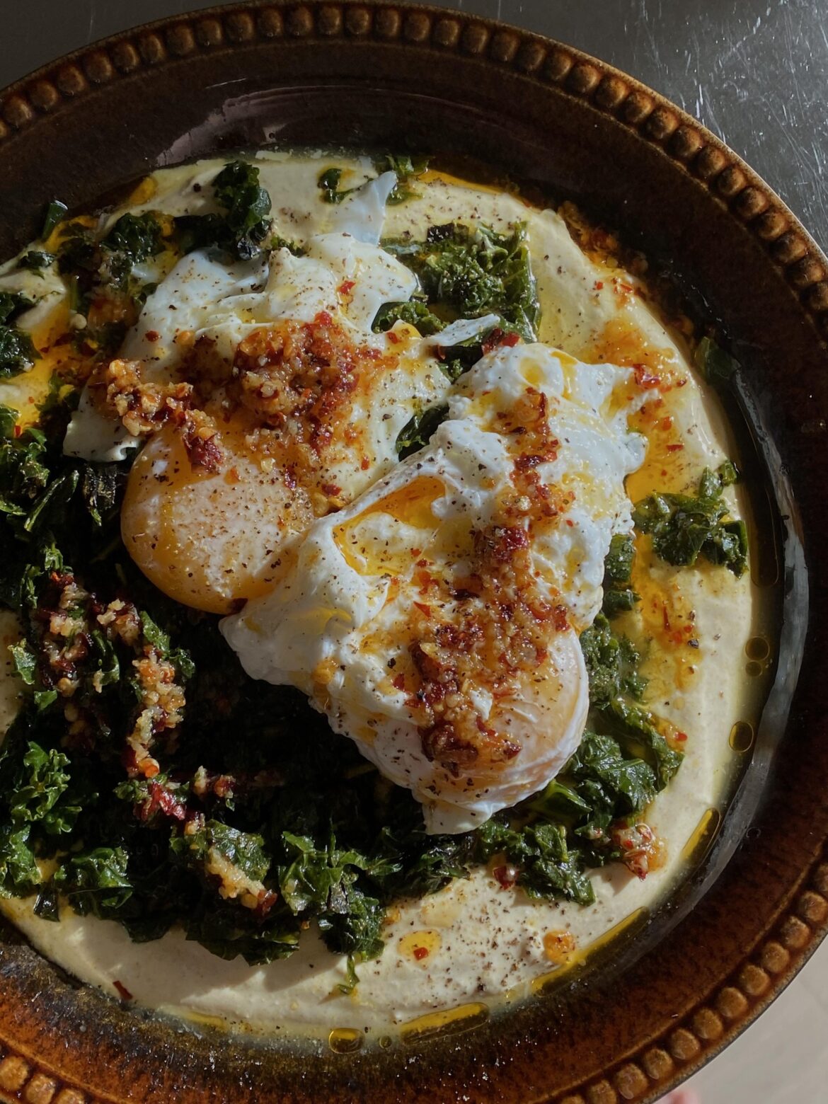 Poached egg on top of sautéed kale with turmeric and lemon yoghurt
