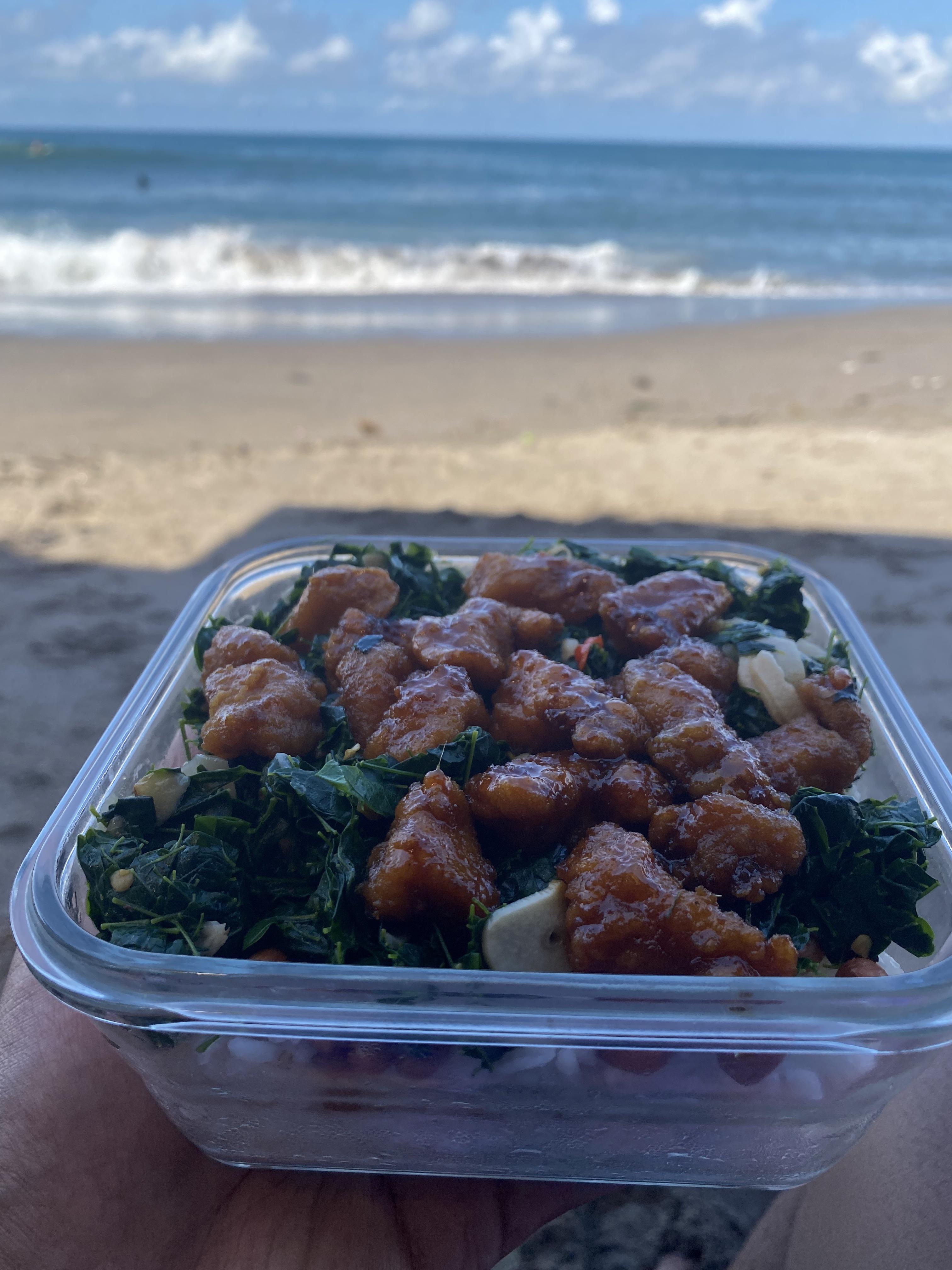Rice, honey fried chicken and moringa leaves bento on the beach