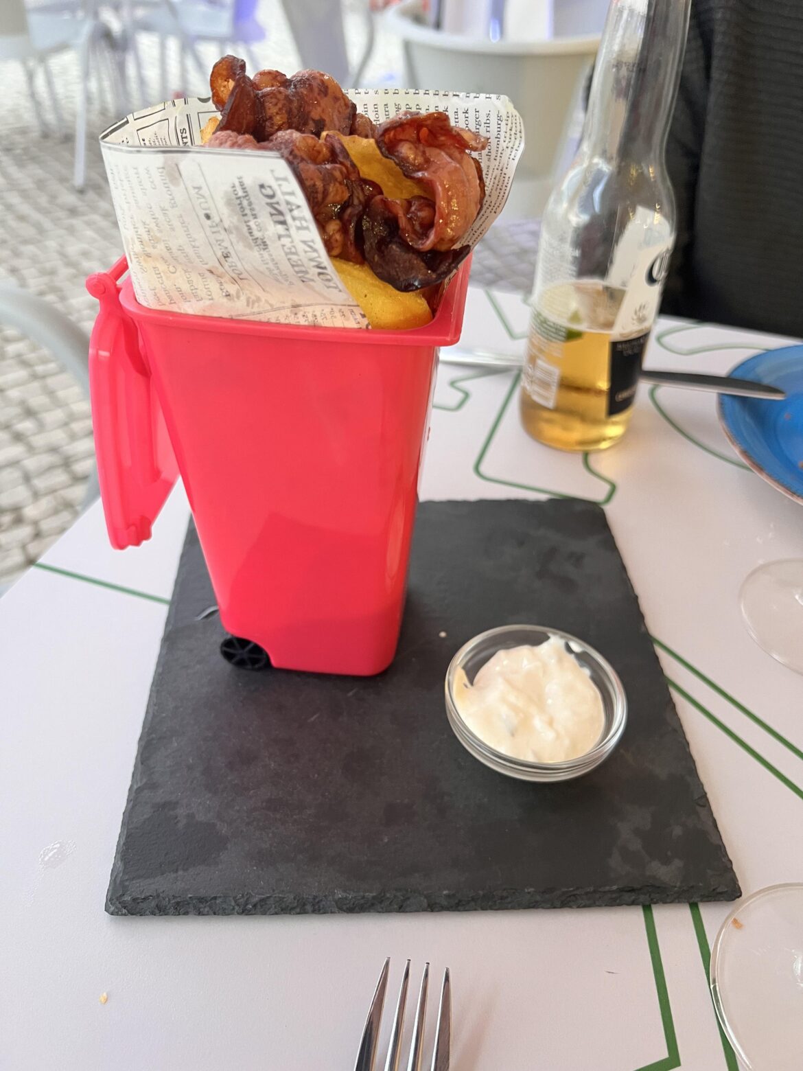 Some fries and bacon in a dustbin