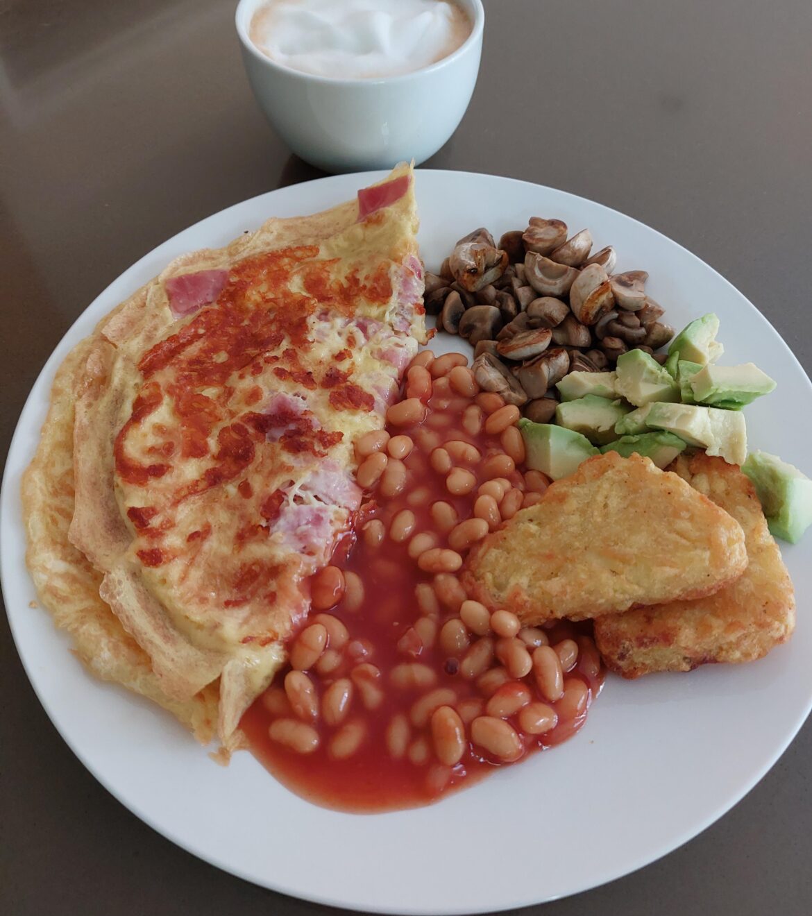 Omelette with ham and cheese, baked beans, mushrooms, hash brown and avocado. 😊