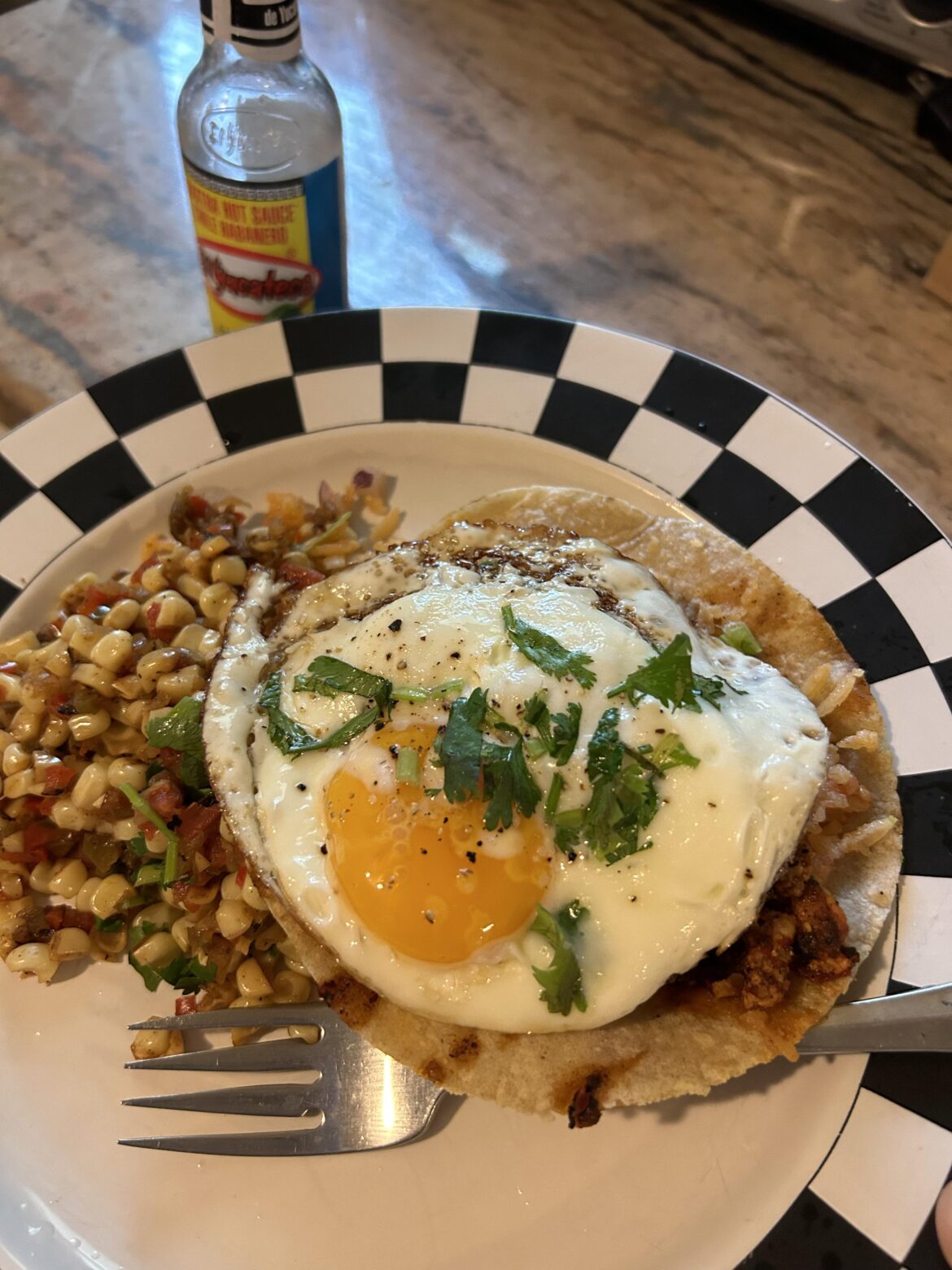 Breakfast chicken and chorizo tostada and corn/pepper salsa with a sunny