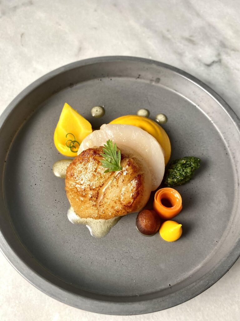 Cold smoked scallop, ginger carrot purée, confit carrot, brown butter emulsion, carrot top gremolatta