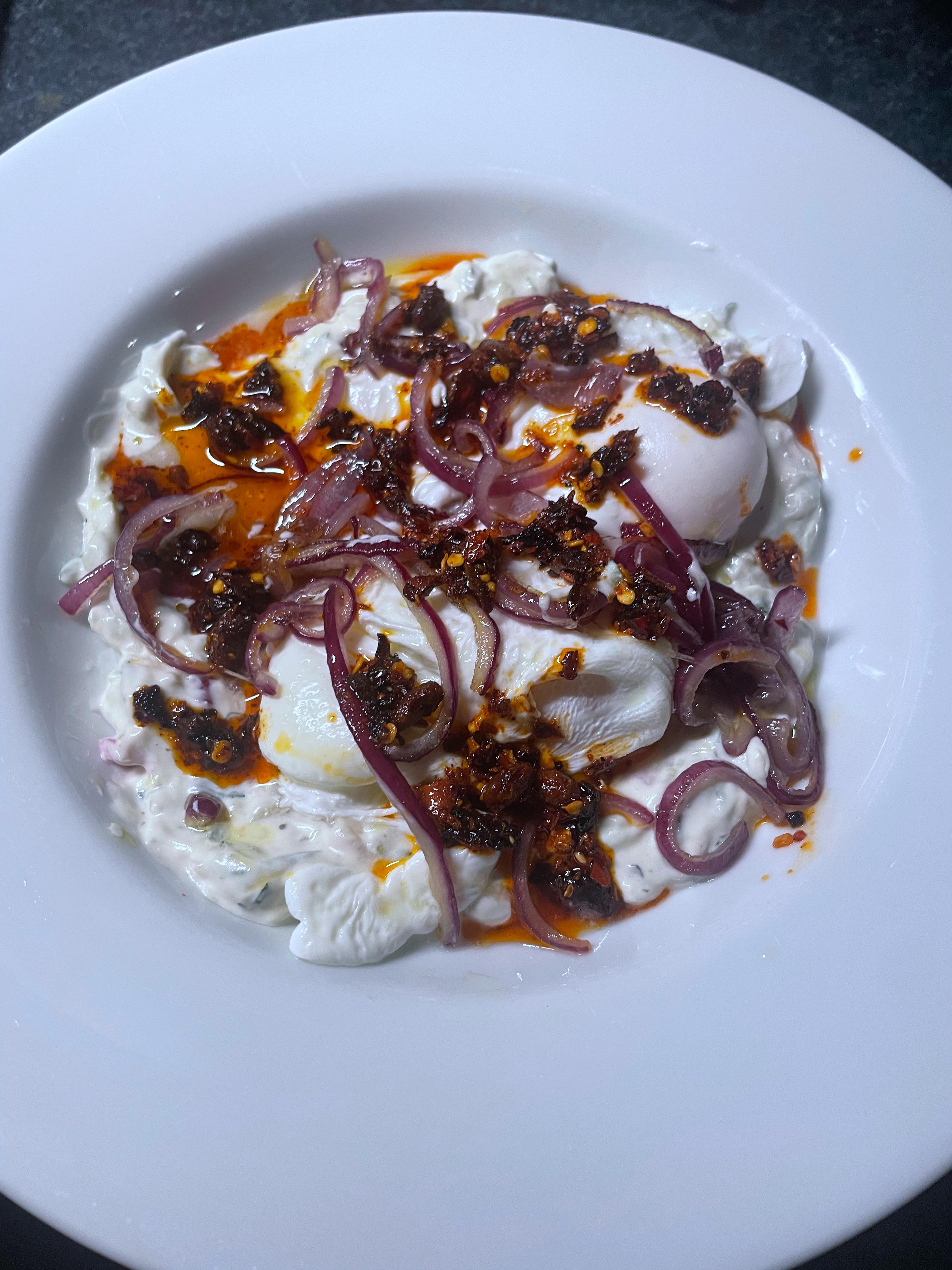 Turkish eggs i Greek style with tzatziki, fried res onions and chili