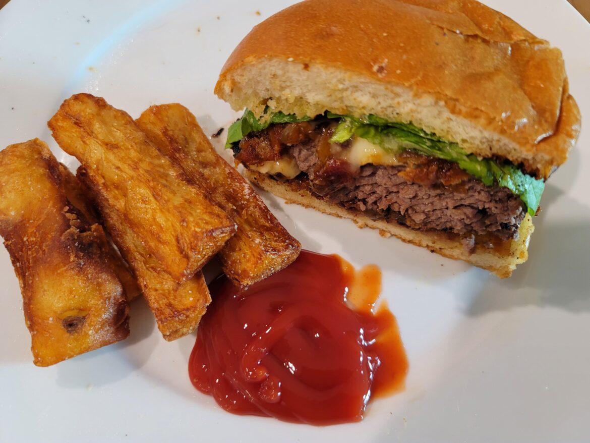 Thick & Juicy Cheeseburger with Brie, Bacon & Onion Jam, Dijon Mustard, and Butter Lettuce on a Toasted Brioche Bun served with Thick-cut, Thrice-cooked Fries.