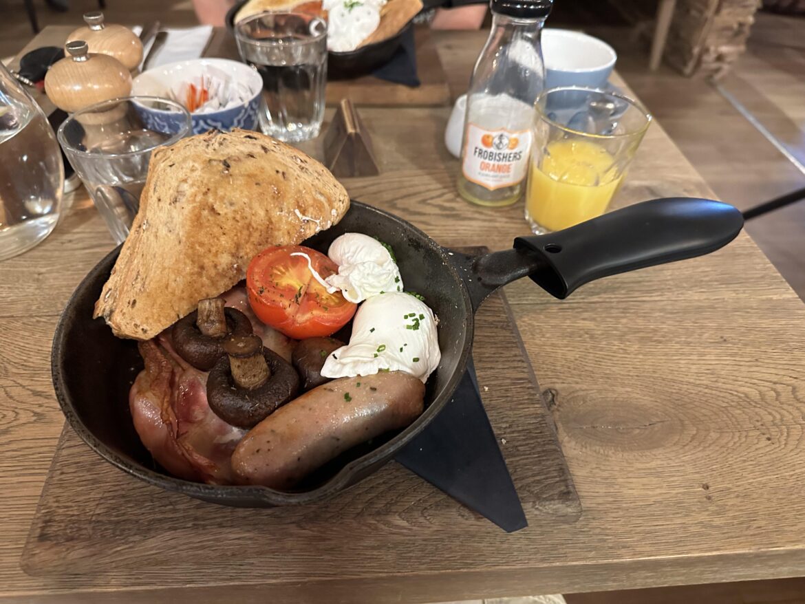 English breakfast in a metal pan on a wooden board