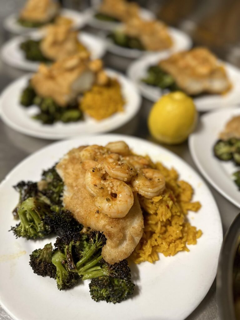Coconut breaded fish w/rice & broccoli, and topped with shrimp.