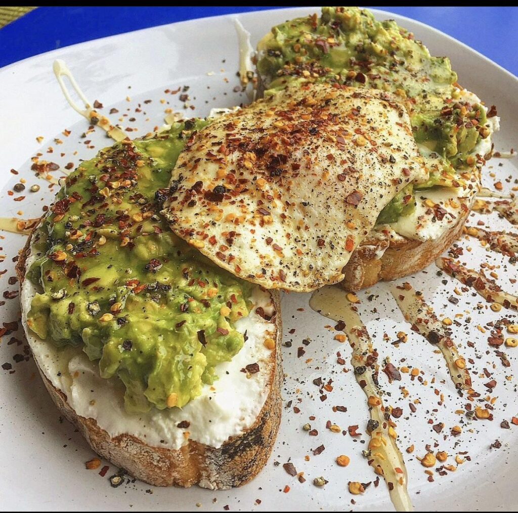 Avocado toast with fried eggs and pepper chili flakes