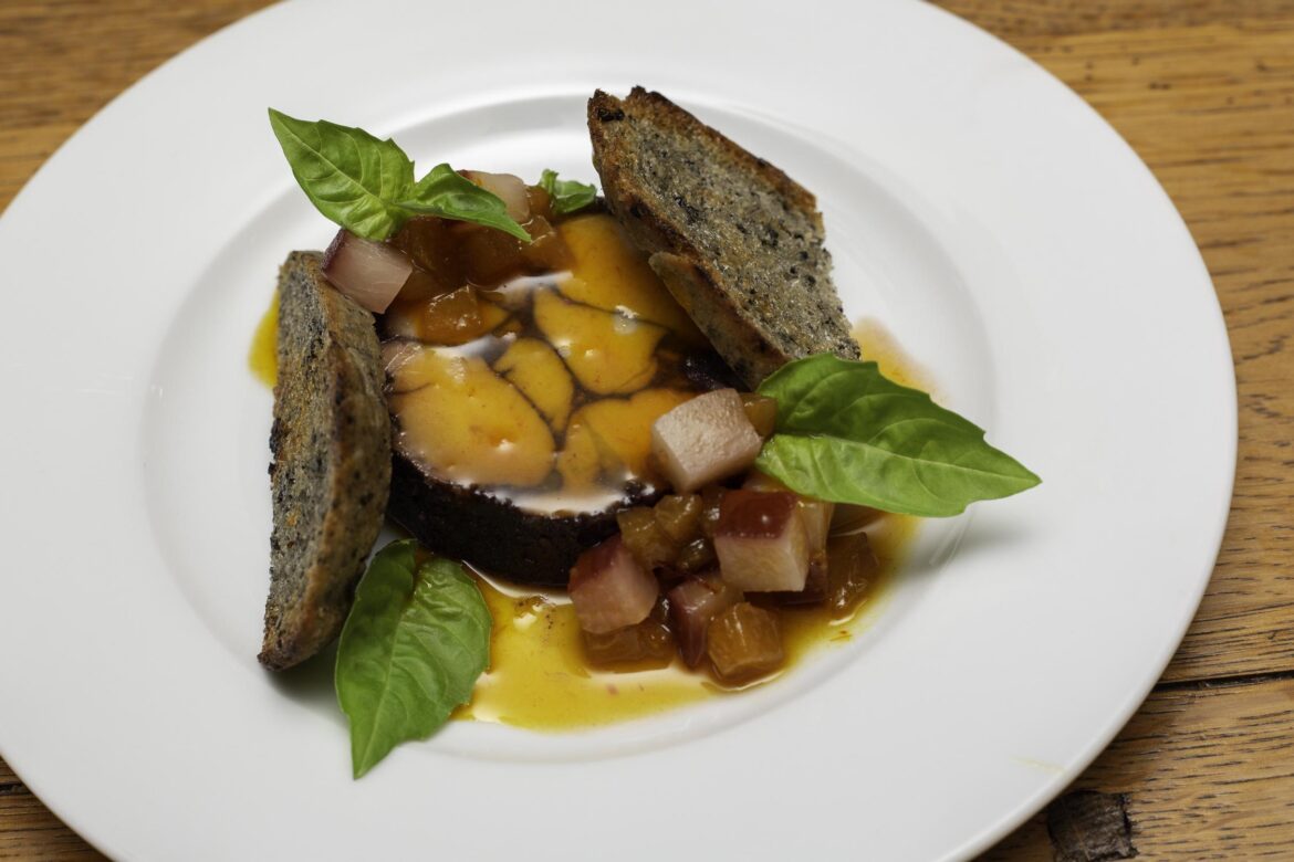 Port and Huckleberry Marbled Foie Torchon, Port Poached White Peach, Pickled Apricot, Black Sesame Sourdough, Basil, Finished with Seabuckthorn Glaze.