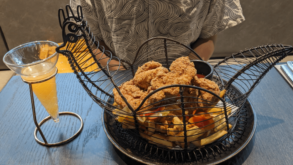 Fried chicken, chips and coleslaw served in a chicken shaped basket. Cocktail served in an ice cream cone shaped glass.