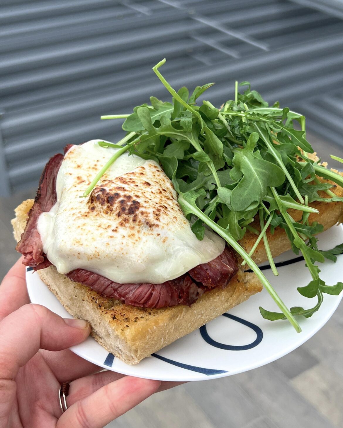Smoked tri tip on garlic bread with provolone and arugula tossed in white balsamic