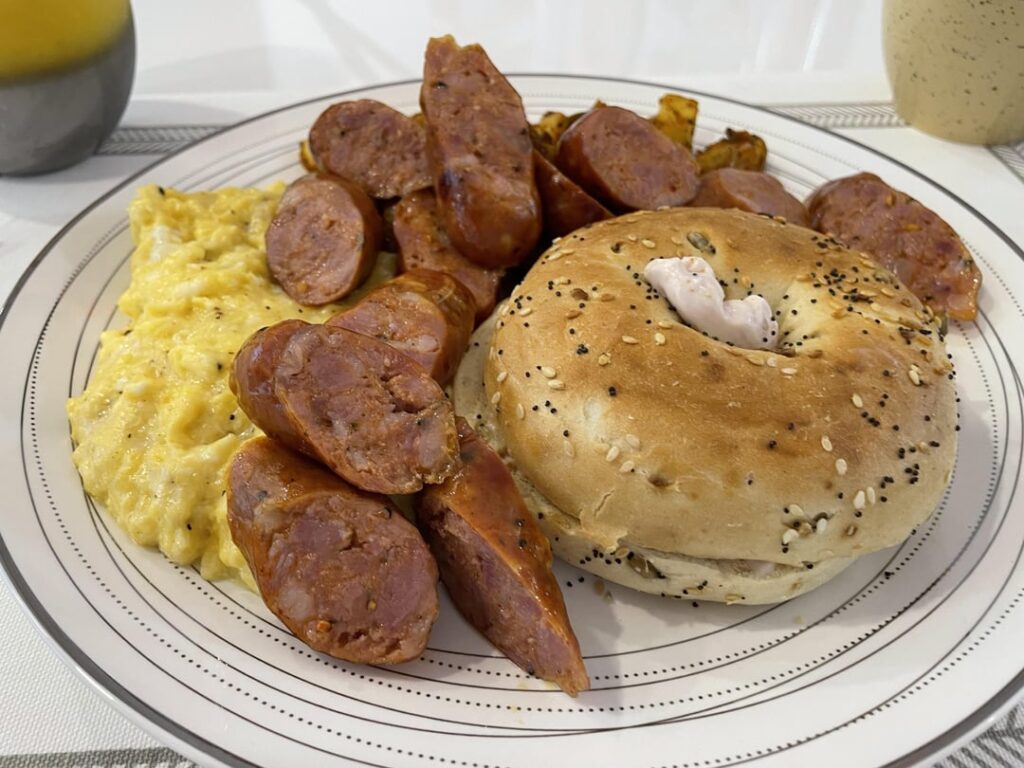 Big Boy Breakfast Cheesy Scrambled Egg W/ Andouille chorizo sausage & Seasoned potatoes & everything bagel with strawberry cream cheese & Green Tea & Orange Juice