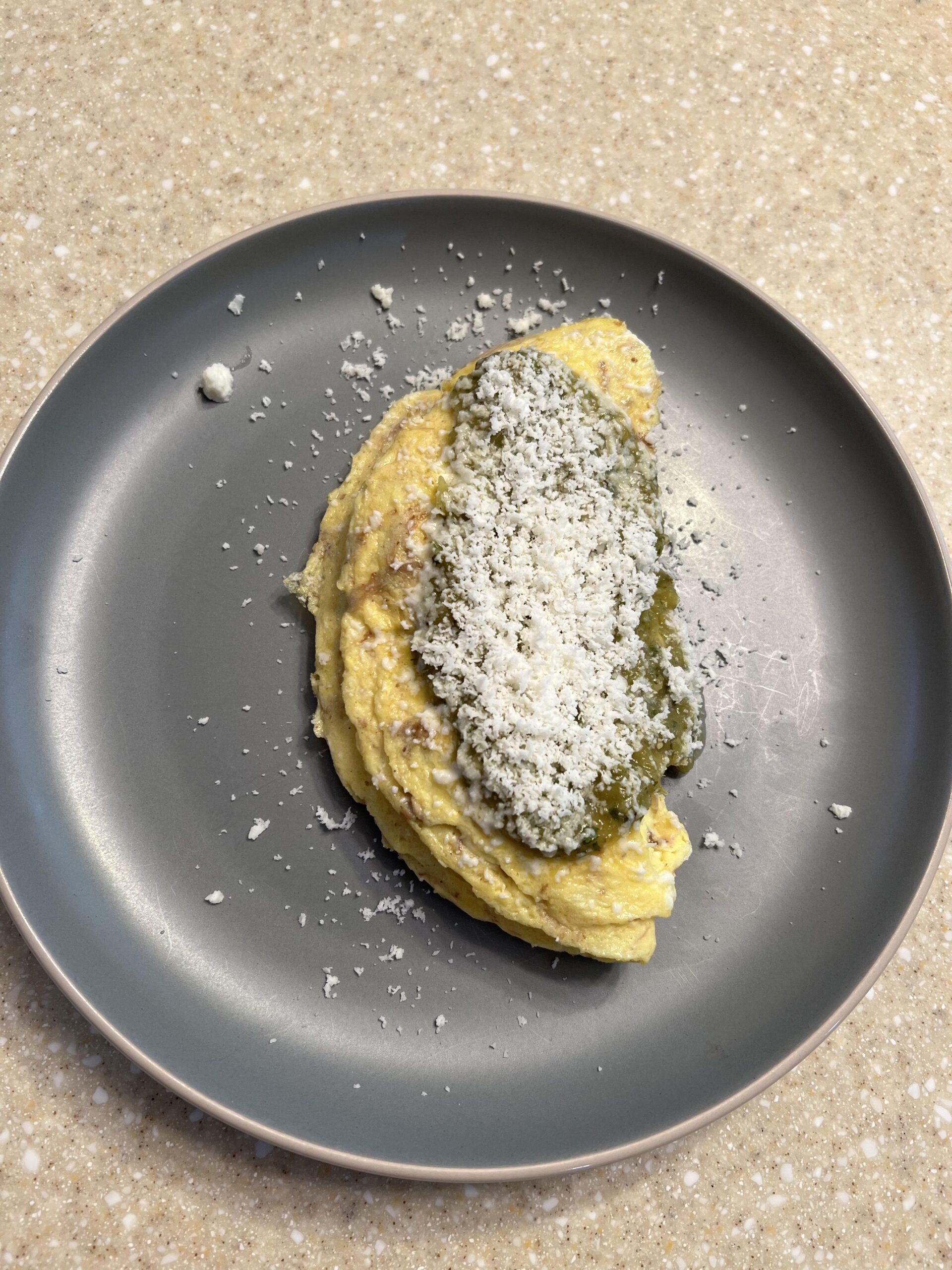 Leftover carnitas omelette topped with salsa verde and queso fresco