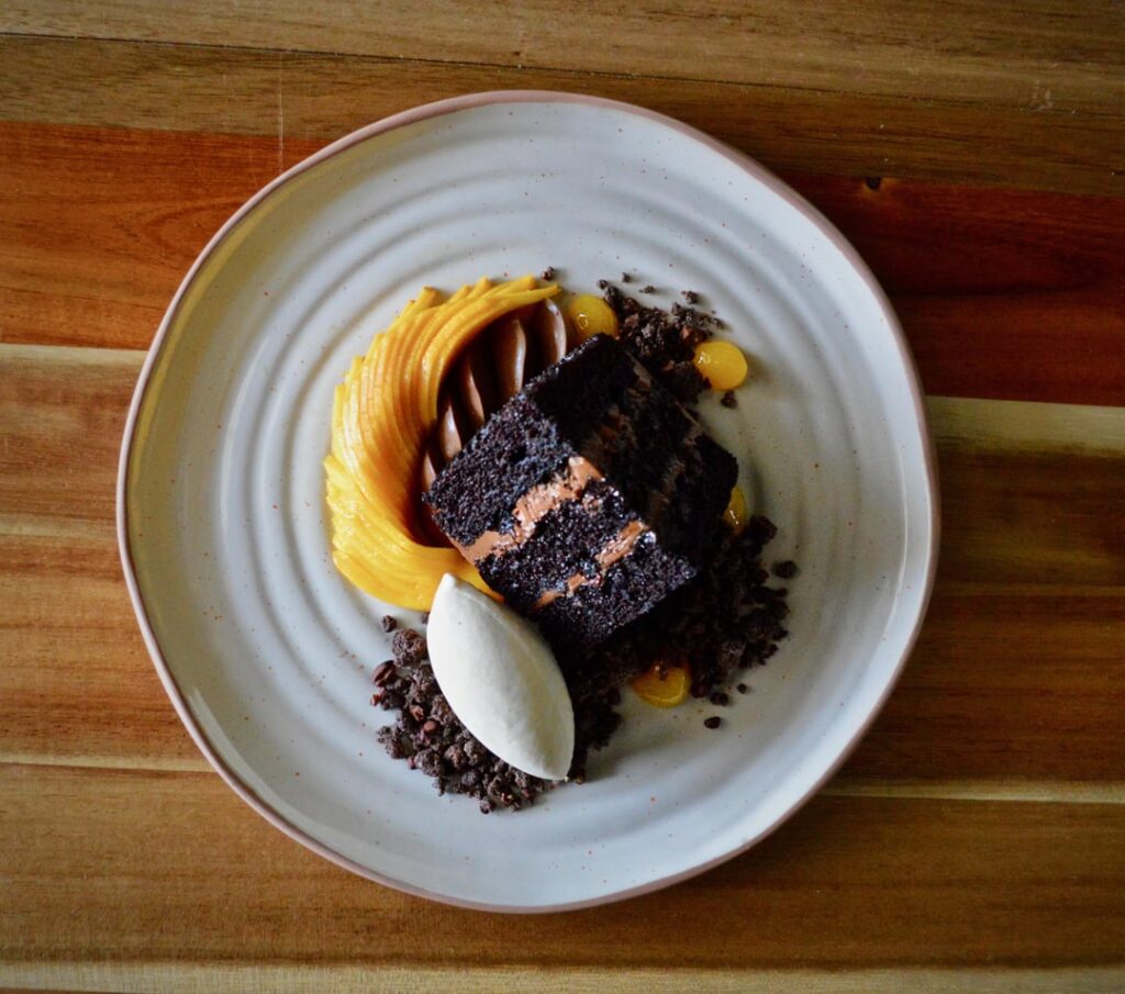 Black Cocoa Chocolate Cake, Honey Mango, Milk Chocolate Cremeux, Cacao Nib Crumble, Brown Sugar Ice Cream