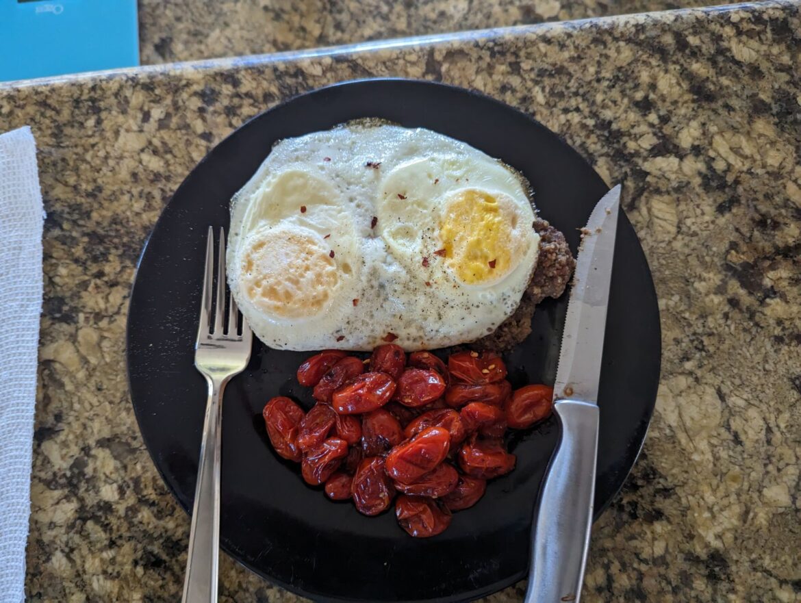 Eggs on Italian meatballs with roasted tomatoes.